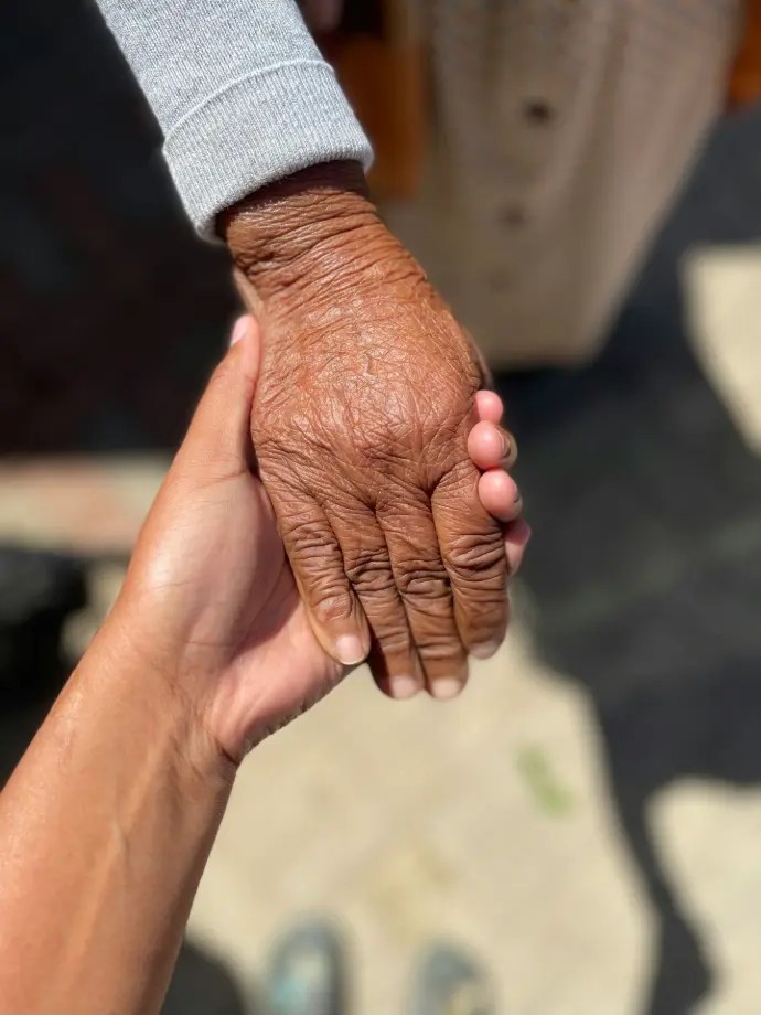 a close up of two people holding hands